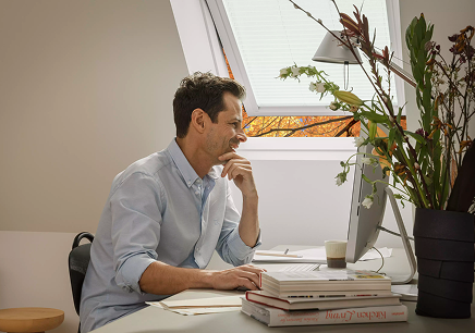 Velux tetőablak mellett dolgozik egy férfi